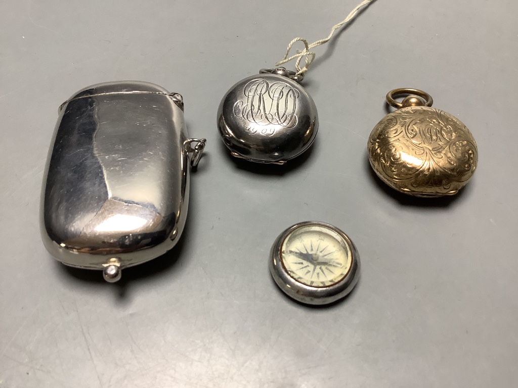 A late Victorian silver sovereign case, a gold plated sovereign case, a plated sovereign/vesta case and a compass.